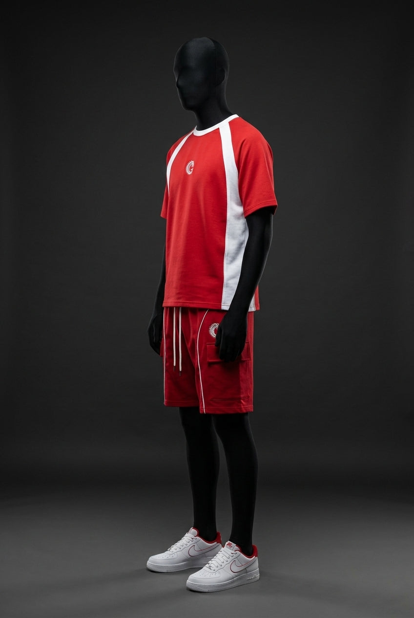 Side angle view of red co-ord set with white shoulder panels, chest logo and cargo pocket shorts