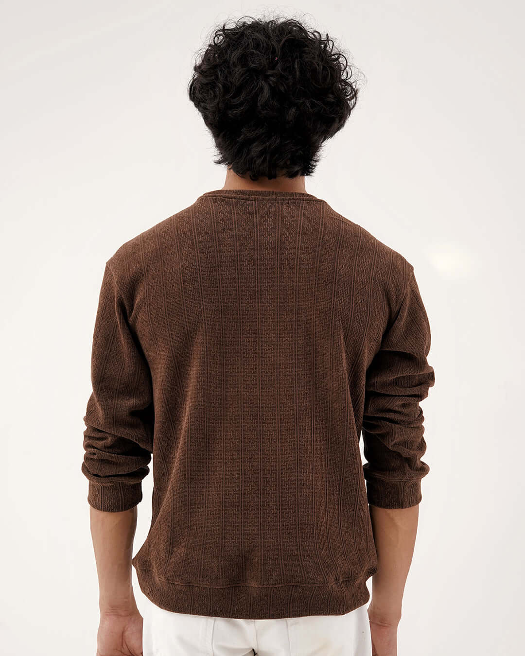 Back view of a man wearing the Daily Luxe Jacquard Sweatshirt – Chestnut Brown, showcasing its rich texture and warm color.