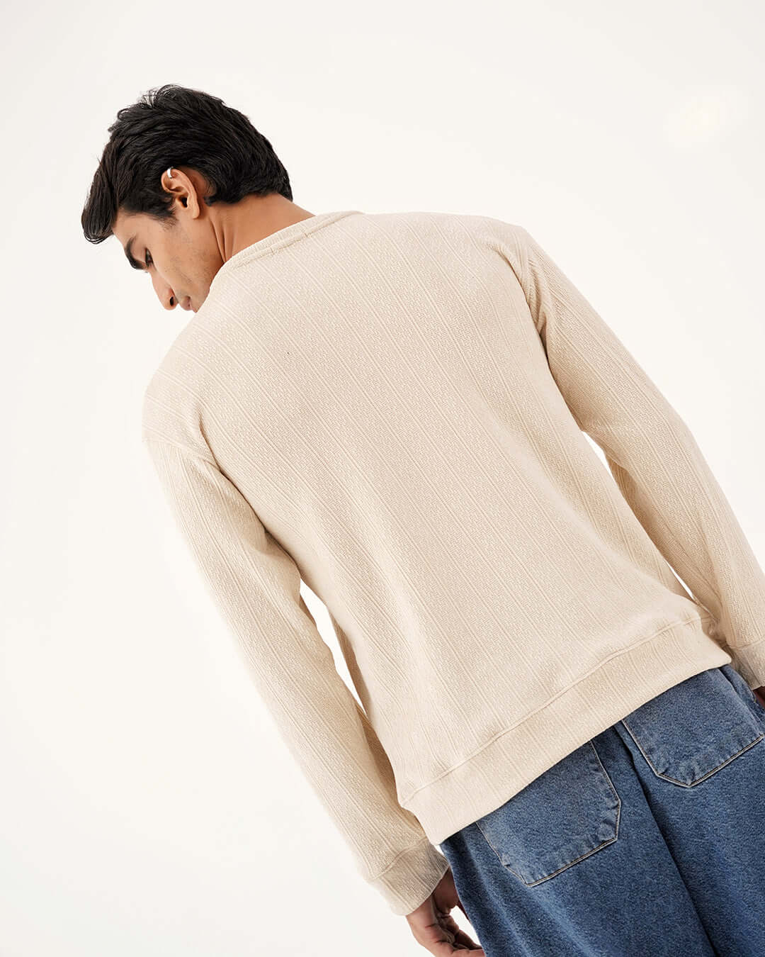 Back view of a model wearing the Daily Luxe Jacquard Sweatshirt – Ivory Cream, showcasing its soft texture and casual fit.