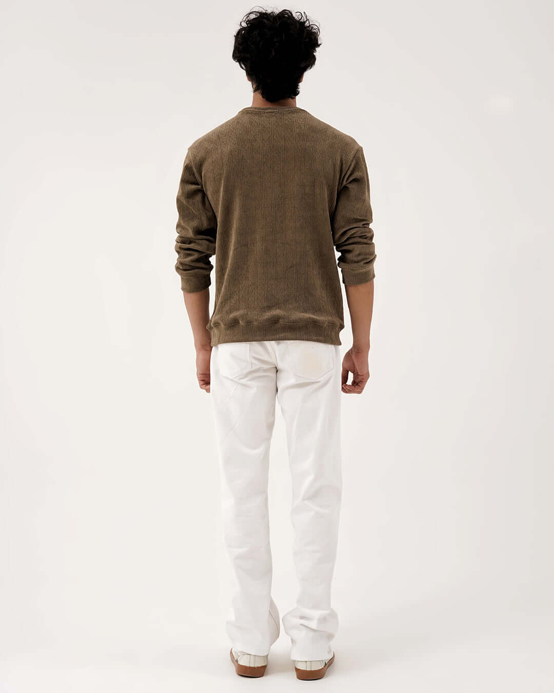 Back view of a man wearing a Daily Luxe Jacquard Sweatshirt in Olive Grove with white pants.