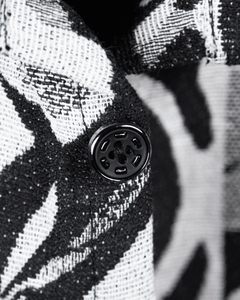 Close-up of Graphic Illusion Shacket showing jacquard fabric and black button detail.