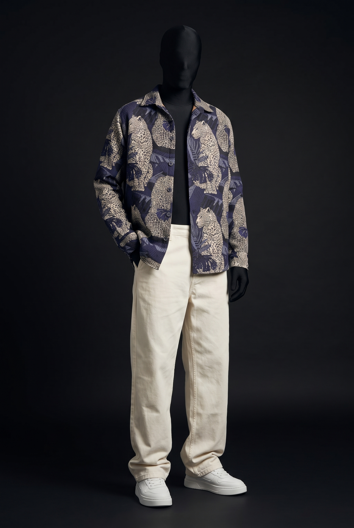 Front view of a navy and cream leopard jacquard overshirt worn open on a mannequin with cream trousers and white sneakers