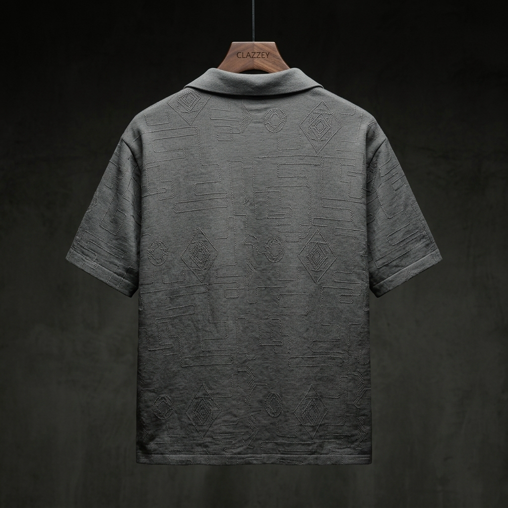 Back of charcoal grey short-sleeve shirt showing tonal embroidered diamond and maze-like geometric pattern, on a wooden Clazzey hanger