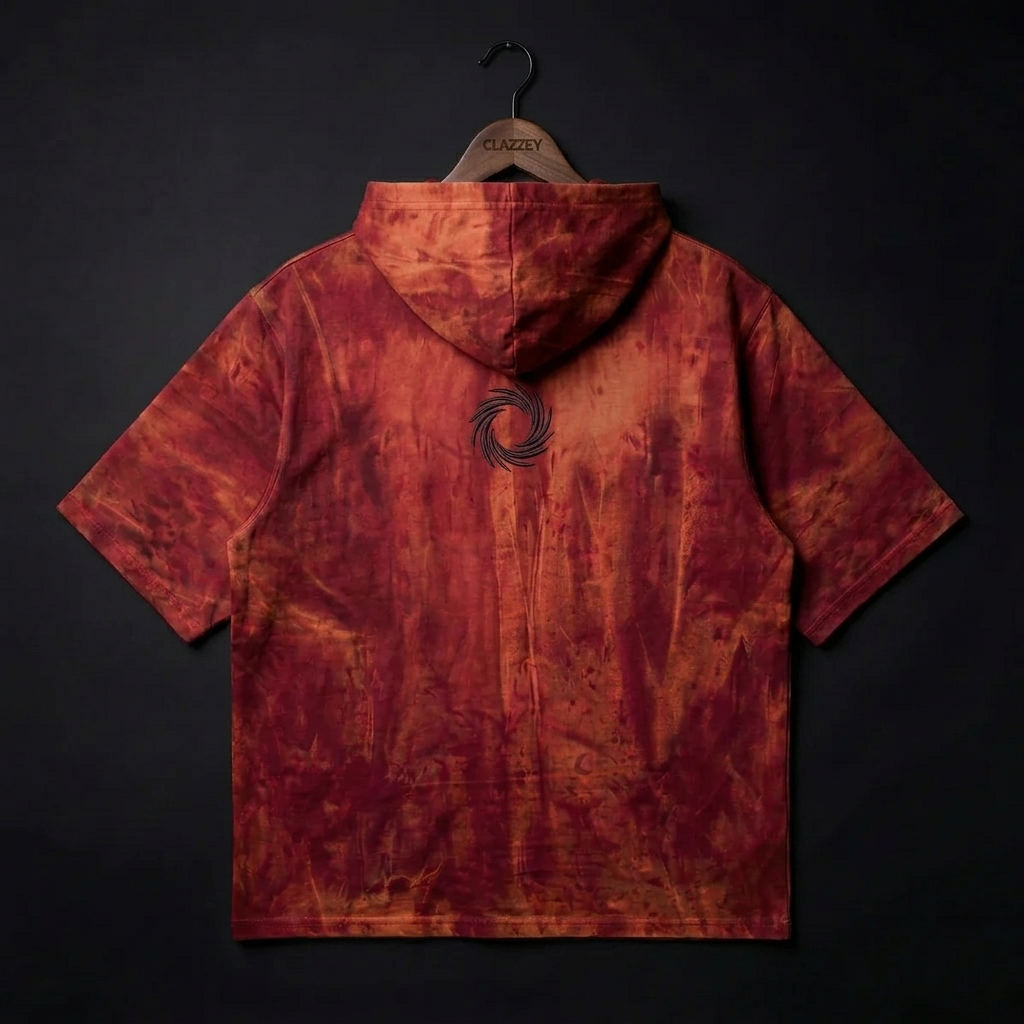 Back of red and orange tie-dye short-sleeve hooded top on hanger, with a dark swirl emblem between the shoulders