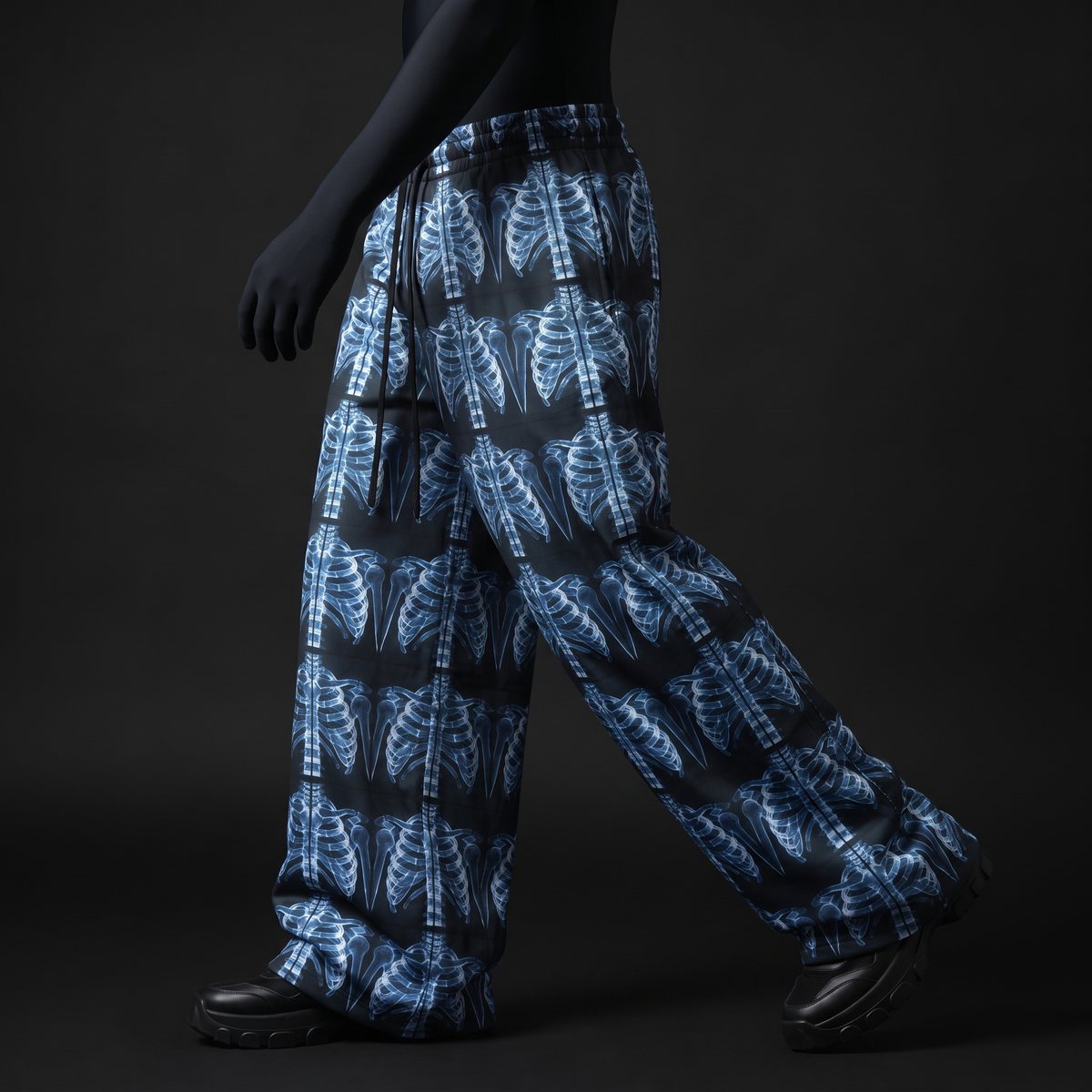 Side view of model walking in baggy pants with blue X-ray ribcage print and black drawstrings