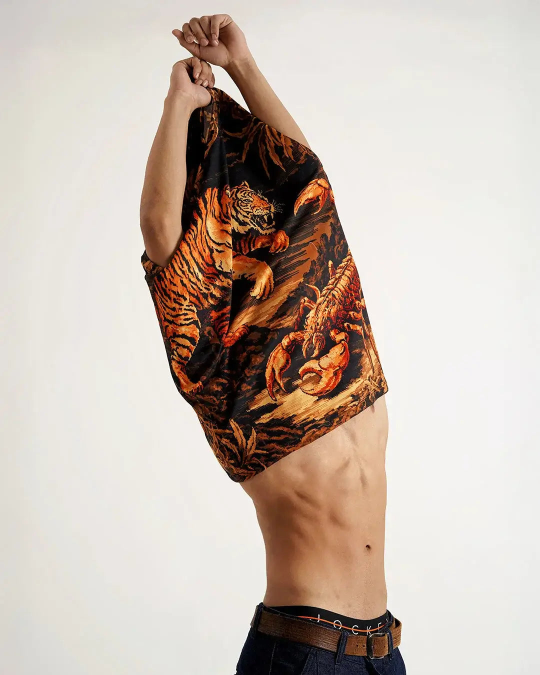 Man pulling on Predator’s Printed Tee with bold tiger graphic, showcasing streetwear style and confidence.